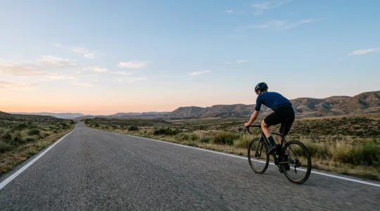 Endurance cyclist maintaining steady pace on open road during long-distance sportive
