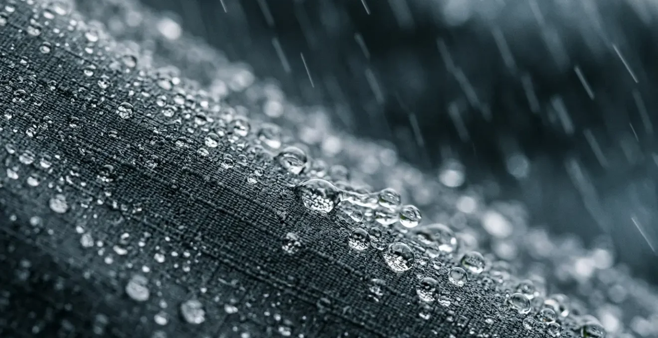 Close-up view of water beading on high-performance cycling jacket fabric during heavy rain