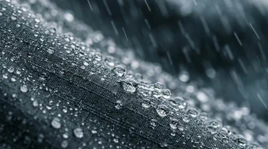 Close-up view of water beading on high-performance cycling jacket fabric during heavy rain