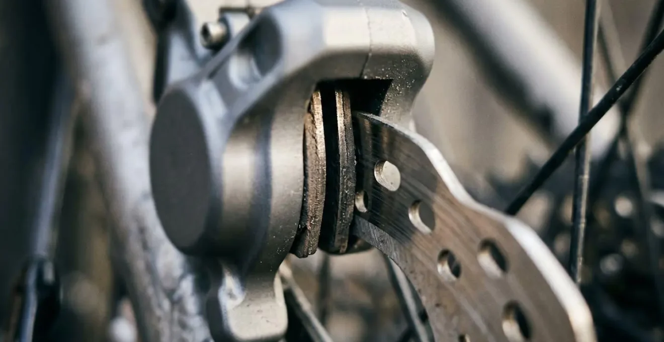 Close-up of disc brake caliper showing brake pad thickness measurement with minimal clearance