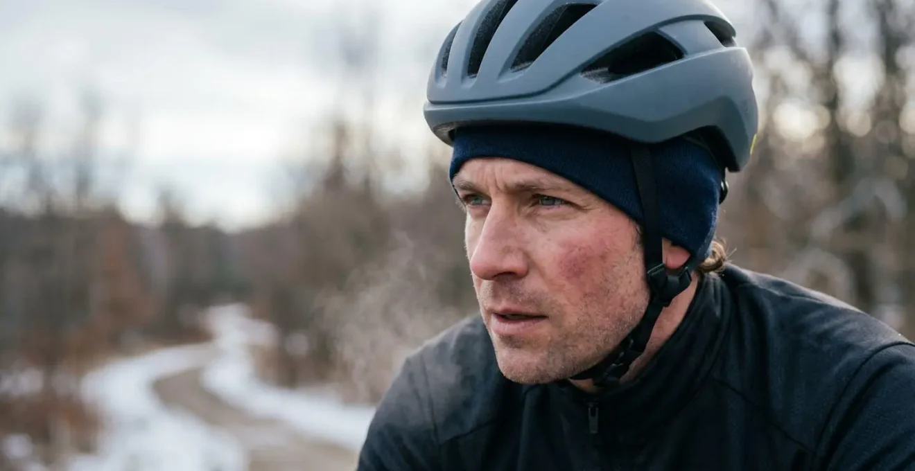 Close portrait of cyclist wearing thermal skull cap under helmet in cold conditions