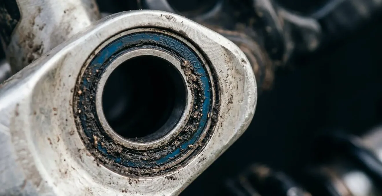 Extreme macro shot of mountain bike rear suspension pivot bearing showing intricate mechanical details and potential wear points