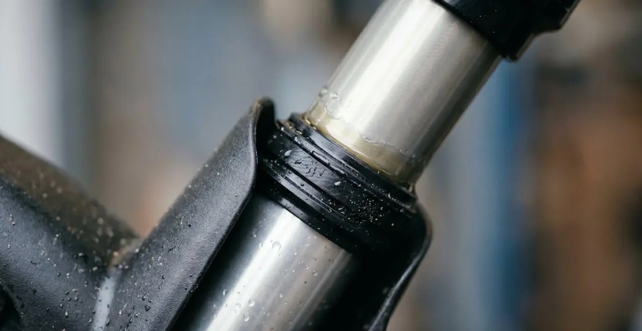 Close-up macro view of mountain bike rear shock seal with protective mudguard installed